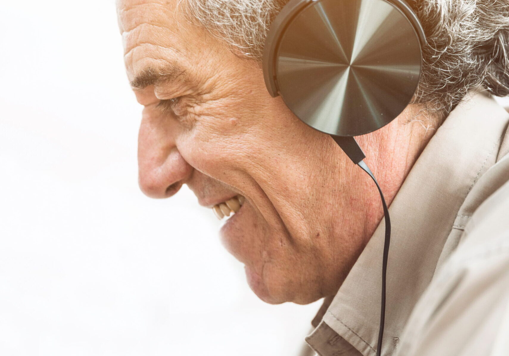 senior-man-listening-music-headphone-against-white-background (1)